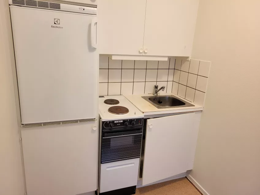 A corner kitchenette, with a half-size oven, a sink and a combined refrigerator/freezer. Photo: Mikko Jokela Måsbäck