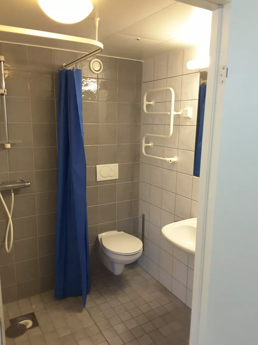 Overview over bathroom in room E1103 at housing area Klostergården Student house showing shower, toilet and sink.